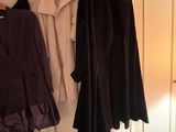 two coats hanging on a clothes rack in a room