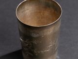 an old silver cup sitting on top of a black table