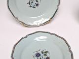 three plates with floral designs on them sitting on a white surface