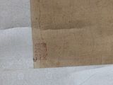 a piece of brown paper with a red stamp on it