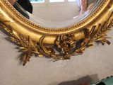 a gold mirror on the wall in a room