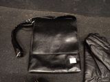 a black purse and a pair of gloves on the ground