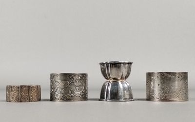 un ensemble de cinq serviettes et tasses en argent posées sur une table