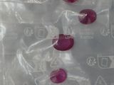 un sac en plastique contenant un tas de perles rouges