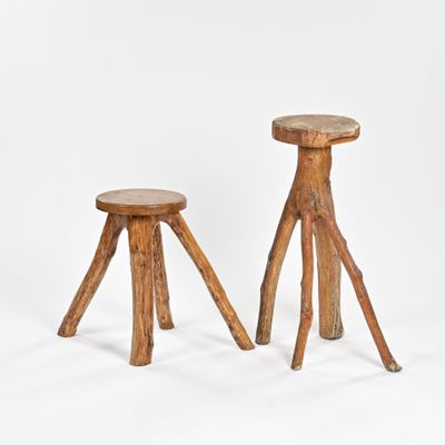 deux tabourets en bois placés l'un à côté de l'autre sur une surface blanche