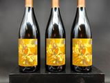 trois bouteilles de vin posées sur un bloc de bois