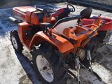 an image of a small orange tractor parked in a parking lot