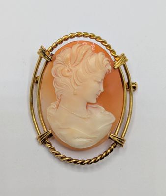 un gros plan sur une broche représentant le visage d'une femme