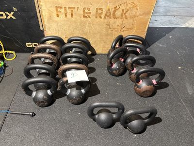 de nombreux kettlebells posés par terre à côté d'une caisse