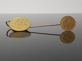 deux pièces d'or posées l'une sur l'autre sur une table