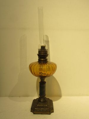 an old fashioned oil lamp sitting on top of a white table