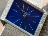 a close up of a blue square watch on a leather strap