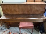un piano qui se trouve dans le coin d'une pièce