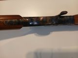 an old rifle with a wooden handle on display in a museum