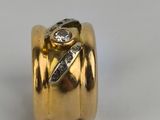 a close up of a gold ring with a diamond on it