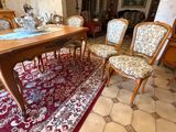 une table de salle à manger avec des chaises et un tapis au sol