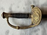 an old sword with a gold handle on a white surface