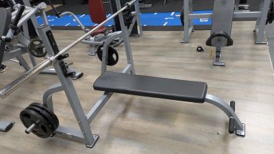 a gym with a bench, weights, and other equipment on the floor