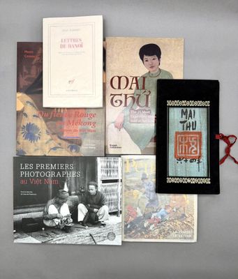 Plusieurs livres et une paire de ciseaux sont posés sur une table