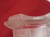 a close up of a clear vase on a red surface
