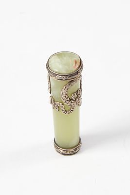 un vase vert orné d'un oiseau, posé sur un fond blanc