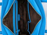the inside of a blue purse with a zipper open