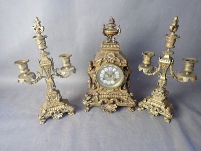 trois bougies et une horloge posées sur une table