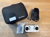 a remote control, a bag, and other items on the floor