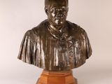 un buste en bronze représentant un homme vêtu d'une chemise et d'une cravate