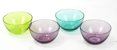 trois bols en verre de couleurs différentes posés sur une surface blanche