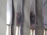 four knives that are sitting next to each other on a table