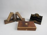 trois petites boîtes en bois et un porte-livre posés sur une surface blanche