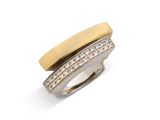un gros plan d'une bague sertie de diamants sur une surface blanche