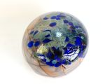 a glass ball with blue and green speckles on it