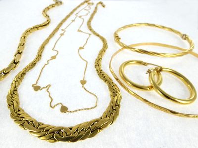 a lot of gold necklaces and bracelets on a table