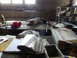 a room with a lot of papers and a laptop on the table