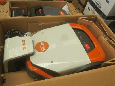 une boîte contenant un aspirateur et un chargeur
