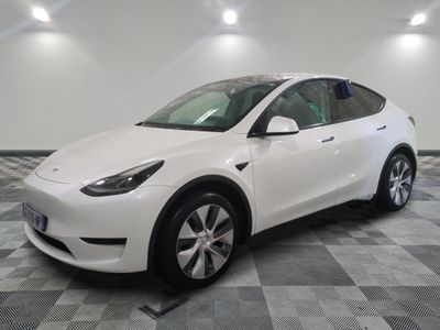 a white tesla suv parked in a garage with a checkered floor