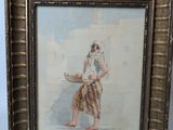 painting of a woman carrying a basket of fruit in a gold frame