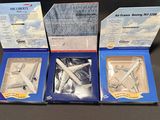 three boxed boxes of model airplanes sitting on a black surface
