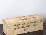 une caisse en bois sur laquelle est collée une étiquette de vin, posée sur une table
