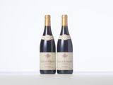 two bottles of wine sitting on top of a table next to each other