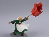 figurine of a woman holding a red umbrella on a gray surface
