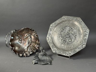 une assiette en argent posée à côté d'une assiette en argent sur laquelle est représenté un oiseau