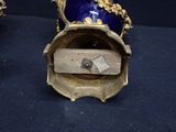 a blue vase with a gold decoration on top of it