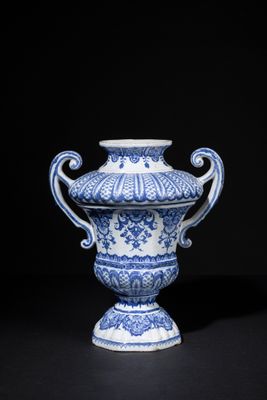 blue and white vase with handles on a black background