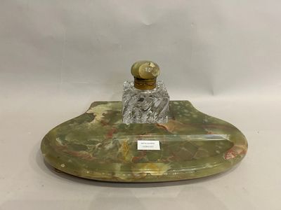 un objet vert et doré sur une surface blanche