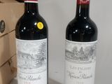 two bottles of wine sitting next to each other on a table