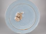 une assiette bleue sur laquelle se trouve un petit morceau de nourriture