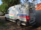 a van that is parked next to a tree